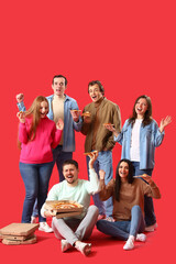 Group of happy friends with tasty pizza on red background