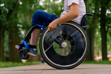 Inclusiveness A man with a disability does wheelchair stunts in a city park against a backdrop of...