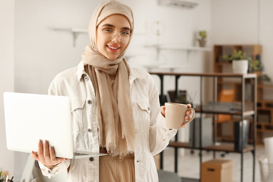 Arabian female programmer with laptop and coffee in office