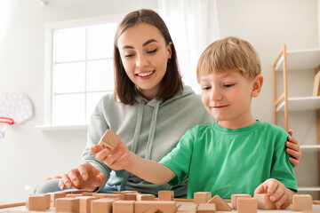 Little boy and nanny playing with cubes at home