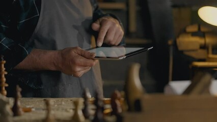 Sawmill, workshop worker Works with electronic tablet looks at the screen In the working room The camera is in motion Junior specialist Works at the carpentry table In the workshop, carpentry tools