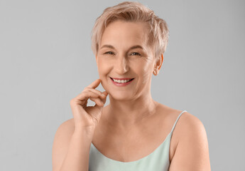 Mature woman with marked face for filler injection on light background