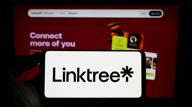 Stuttgart, Germany - 07-09-2023: Person holding cellphone with logo of Australian Internet company Linktree Pty. Ltd. on screen in front of webpage. Focus on phone display.