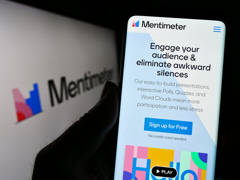 Stuttgart, Germany - 07-09-2023: Person holding smartphone with webpage of presentation software company Mentimeter on screen in front of logo. Focus on center of phone display.