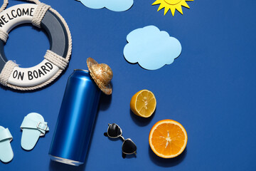 Can of soda with beach decor and citrus fruits on blue background