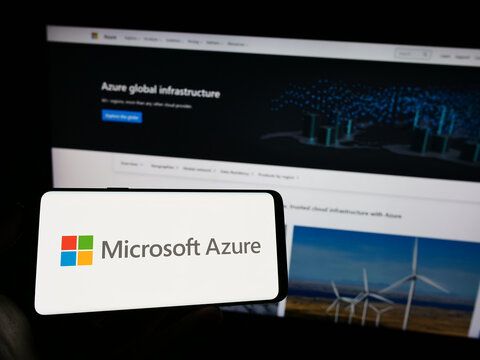 Stuttgart, Germany - 07-11-2023: Person holding mobile phone with logo of cloud computing platform Microsoft Azure on screen in front of business web page. Focus on phone display.