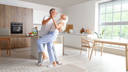 Mature couple dancing in kitchen