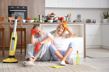 Tired mature couple after cleaning in kitchen