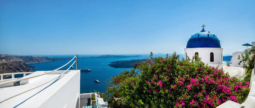 Santorini, Greece. Amazing view of blue cyclades, pink flowers and sea in Santorini. Location: Imerovigli Santorini, Greece. Church of the resurrection of the lord.