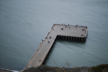 A fishing pier with tourists and people fishing in the San Francisco Bay, as seen from the Golden...