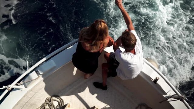 A young couple admires the island from the deck of a ship in the Croatian Adriatic Sea. Boat trips to the nearby Paklin Islands in Croatia. People are sailing on a boat in the Adriatic Sea of Croatia.