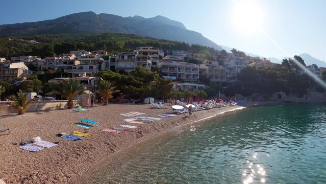 Beach in the Adriatic resort of Brela Croatia. Tourists relax on the pebble beach of Brela.The resort village of Brela on the Adriatic coast of Croatia on the Makarska Riviera