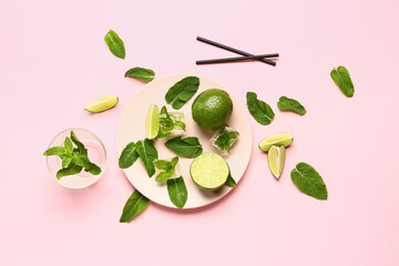 Composition with fresh mint leaves, limes and ice cubes on pink background