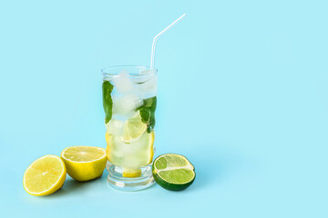 Glass of fresh mojito and citrus fruits on color background