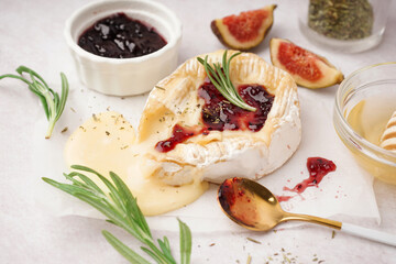 Tasty baked Camembert cheese on light background