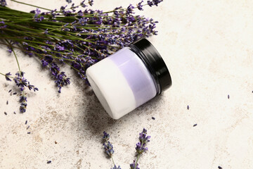 Obraz na płótnie Canvas Jar of cosmetic product and lavender flowers on light background