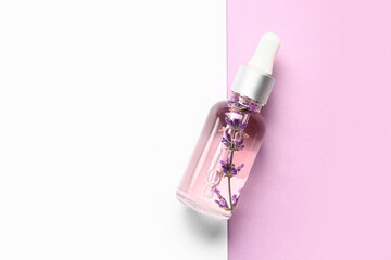 Bottle of lavender essential oil on color background