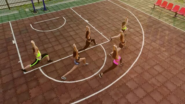Group of cheerleaders in action. Concept of unity and team sport. Training at college high school with young female teenagers. Cheerleading person dance with team support, motivation and hands for