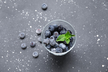 Glass of frozen blueberry with mint leaves on black grunge background