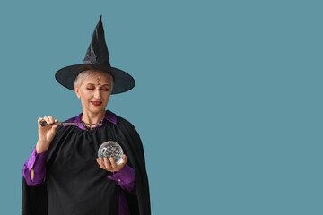 Mature witch with magic wand and crystal ball on blue background