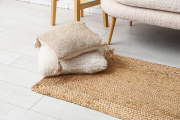 Fototapeta na wymiar Wicker carpet with cushions in interior of living room, closeup