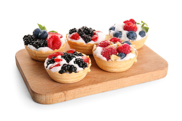 Wooden board of tasty tartlets with whipped cream and berries on white background