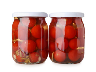 Jars with canned tomatoes on white background