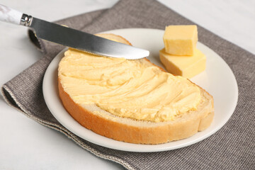 Plate of tasty toast with butter on white background