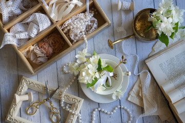 Fototapeta na wymiar Cup of aromatic jasmine tea and fresh flowers on wooden table, flat lay
