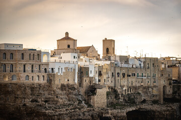Fototapeta premium grottos, caves in polignano a mare, puglia, italy, europe, sunset, cliffs