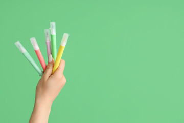 Female hand with felt tip pens on green background