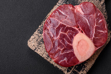 Fresh raw beef steak with bone or ossobuco with salt, spices and herbs