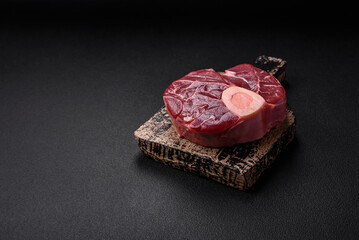 Fresh raw beef steak with bone or ossobuco with salt, spices and herbs
