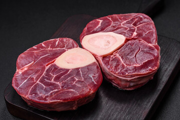 Fresh raw beef steak with bone or ossobuco with salt, spices and herbs
