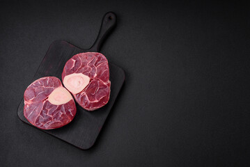 Fresh raw beef steak with bone or ossobuco with salt, spices and herbs
