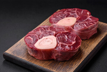 Fresh raw beef steak with bone or ossobuco with salt, spices and herbs