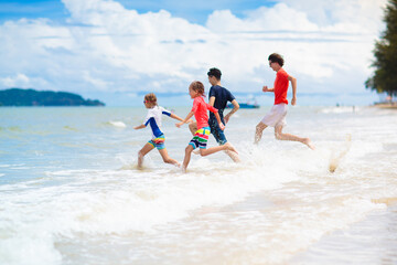 Kids play on tropical beach. Sand and water toy.