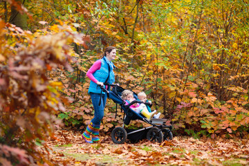 Family hiking with stroller in autumn park