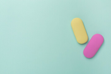 Colorful eraser on color backgroung, top view