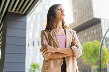 Dreamy businesswoman standing on street