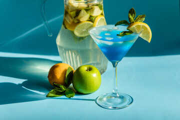 Homemade lemonade with lemon, mint and apple on a blue background