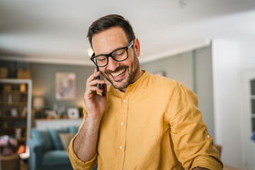 One adult man with eyeglasses stand at home use mobile phone talk