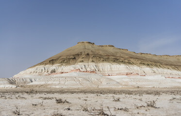 Mount Bokty is layered and multi-colored in the middle of the Kazakh steppe on a sunny spring day, a mountain of different minerals in the desert