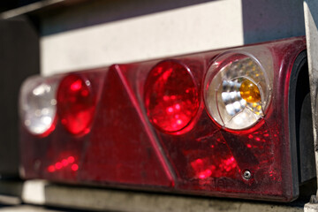 Close-up of the rear light of a truck semi-trailer with a damaged body.
