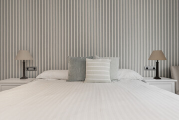 Bed in a bedroom with bedside tables with twin lamps