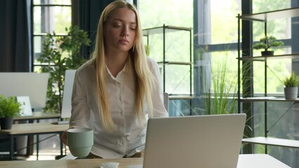 Caucasian businesswoman come to office sit at desktop female manager programmer girl woman drink coffee tea pause start working day check email typing laptop business project e-commerce computer work 