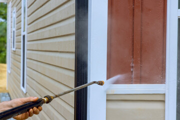 For washing siding houses service worker relies on high pressure nozzles to distribute water soap cleaner effectively.