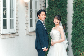 Fototapeta premium 結婚式で結婚式場の庭で前撮りをする新郎新婦（ガーデンウェディング） 