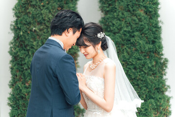 結婚式で結婚式場の庭で前撮りをする新郎新婦（ガーデンウェディング）
