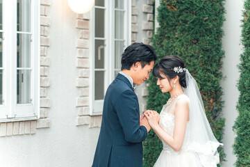 Naklejka premium 結婚式で結婚式場の庭で前撮りをする新郎新婦（ガーデンウェディング） 